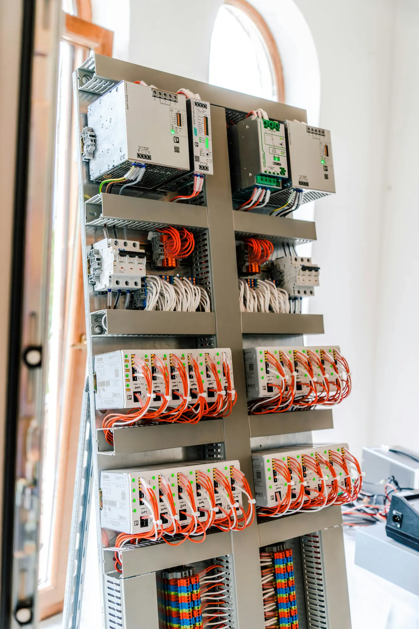 Montageplatte mit Netzteilen, Schutzschaltern und verdrahteten Modulen auf Hutschienen